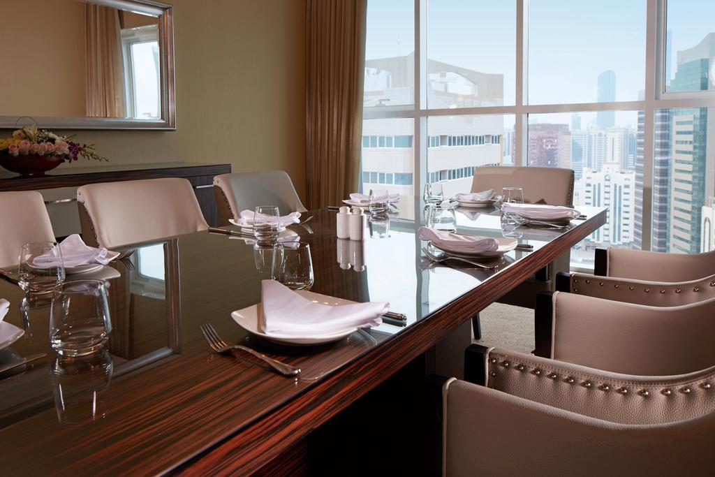 Jannah Burj Al Sarab Hotel Abu Dhabi Exterior foto A dining room in a suite at the Ritz-Carlton, Singapore