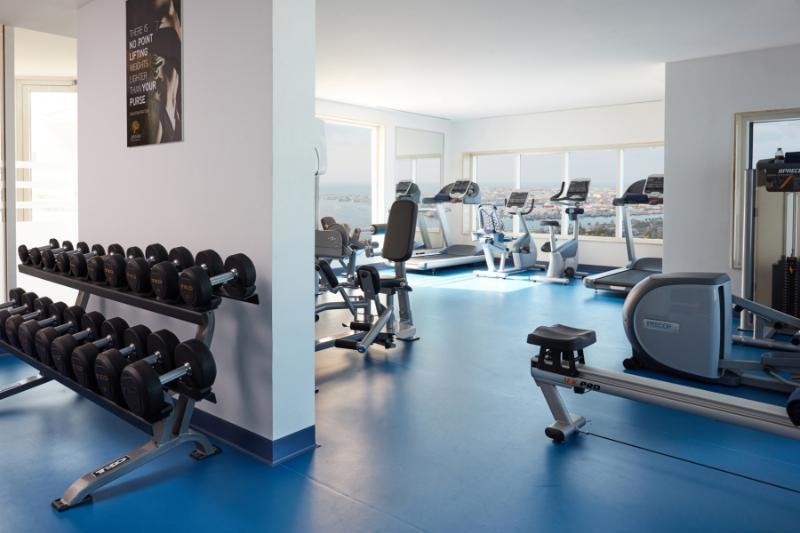 Jannah Burj Al Sarab Hotel Abu Dhabi Exterior foto The photo shows a modern gym or fitness area. On one side, there is a rack of dumbbells arranged in order of weight. In the background, several pieces of gym equipment are visible, including treadmills and stationary bikes. The space features large w